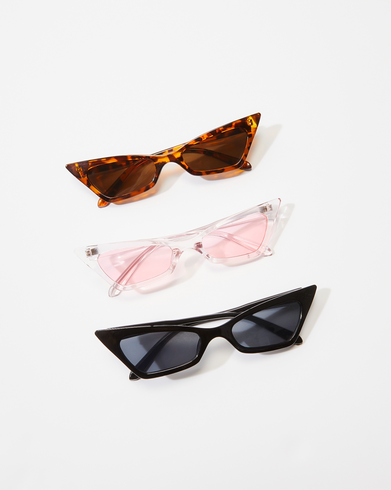 Three cat-eye sunglasses styled in a row on white background