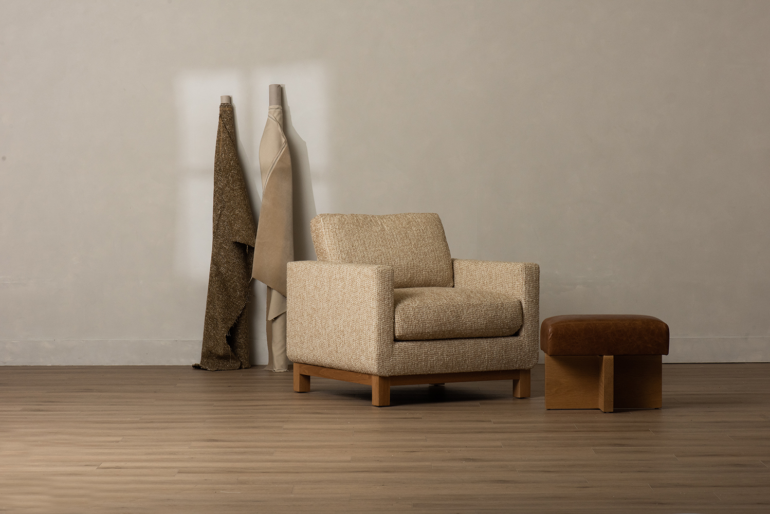 Minimal upholstered chair and ottoman in a studio
