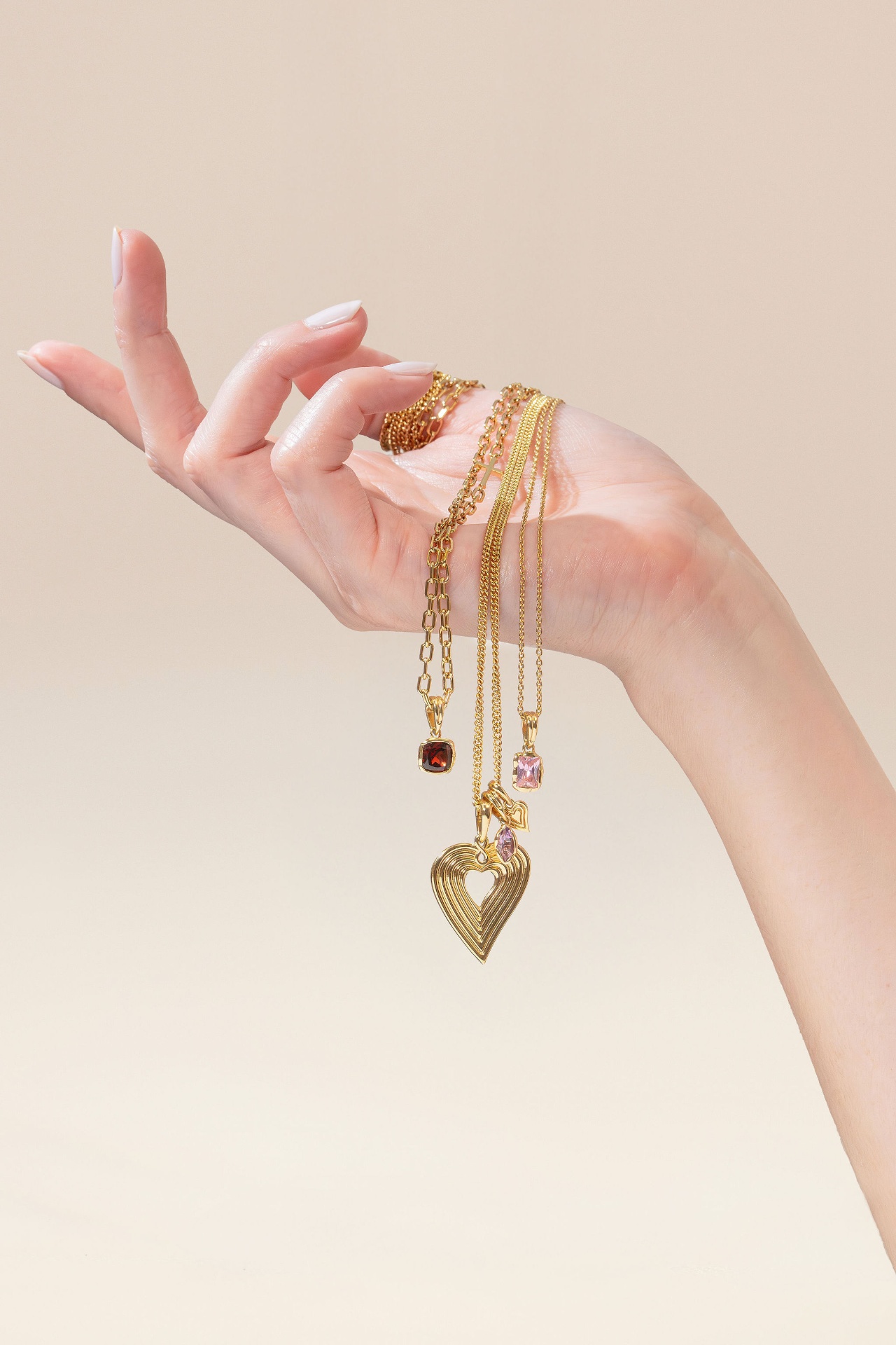 Rizen necklaces draped on a hand
